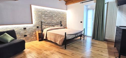 CasoliDietro le mura的一间卧室设有一张床和砖墙
