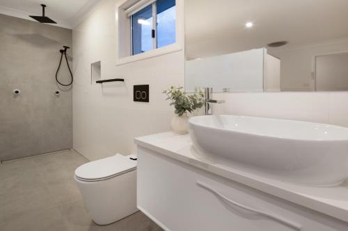 悉尼Beach Retreat的白色的浴室设有水槽和卫生间。
