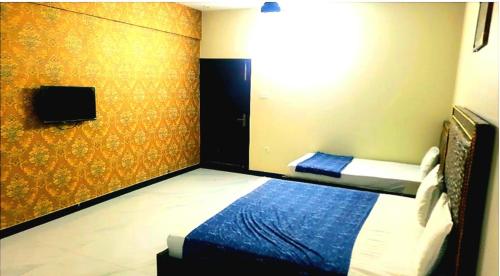 卡拉奇Hotel Sky Inn Gulsan的一间带一张床的卧室,位于带电视的客房内