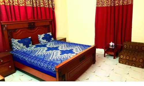 卡拉奇Hotel Sky Inn Gulsan的一间卧室配有床和红色窗帘