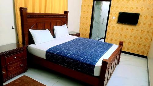卡拉奇Hotel Sky Inn Gulsan的一间卧室配有一张带蓝色毯子的大床