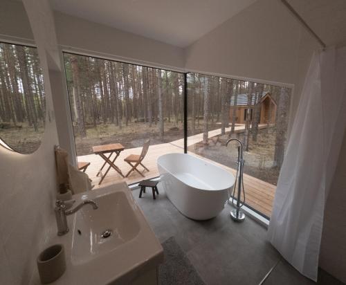 SimistiWUUD Pädaste的带浴缸的浴室,享有甲板的景色