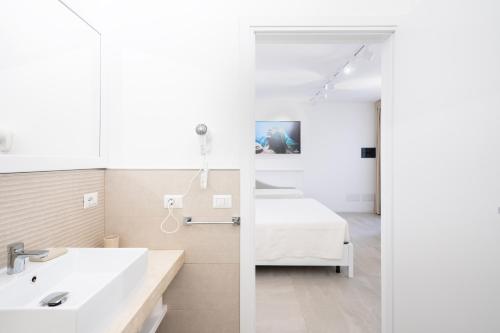 索拉纳斯Istedda Boutique Hotel的浴室设有床、水槽和镜子