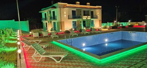 第比利斯Sierra Hotel Tbilisi的夜间在房子前面的游泳池