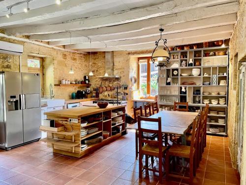 Saint-CybranetEsparoutis的厨房配有桌子和不锈钢冰箱。