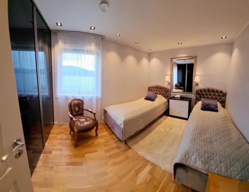 卑尔根Bergen Sunrise Terrace Apartment的一间卧室配有两张床、一把椅子和镜子