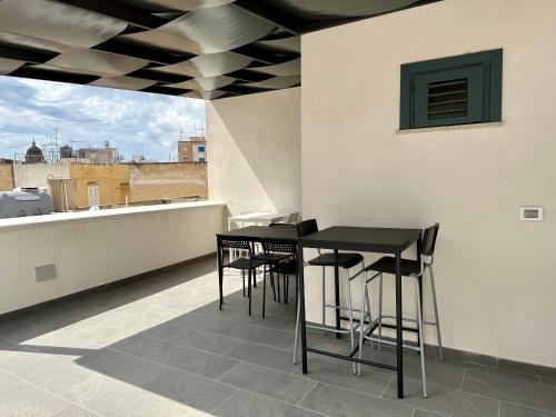 马尔萨拉La Corte 25的屋顶上的一张黑桌子和椅子