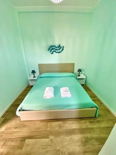 希拉Bilocale Nucarella的一间卧室配有一张带绿色棉被的床