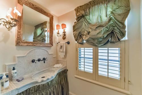 休斯顿Elegant French Patio Home with Private Pool的一间带水槽和镜子的浴室