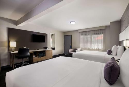 洛杉矶Sunset West Hotel, SureStay Collection By Best Western的酒店客房设有两张床和一台平面电视。