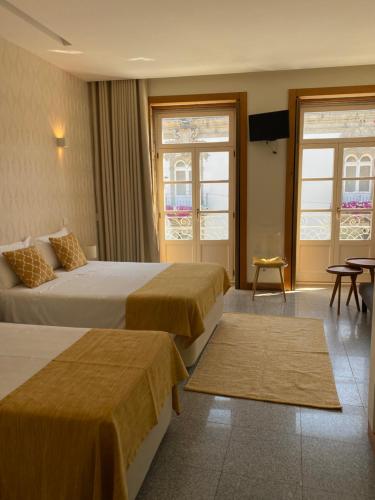 维亚纳堡Enjoy Viana - Guest House的酒店客房设有两张床和电视。