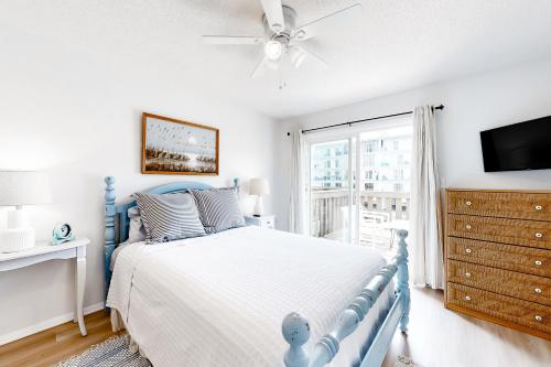 大洋城Bermuda Bay 9的一间卧室设有蓝色的床和窗户。