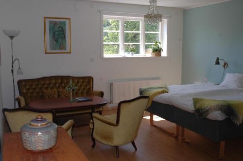 BrokindSundsmåla Landsbygdshotell的卧室配有1张床、1张桌子和1把椅子