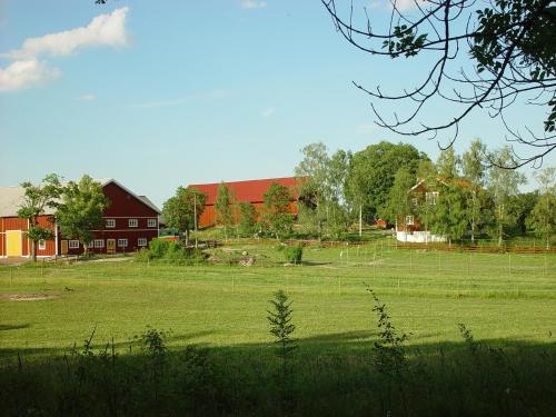 BrokindSundsmåla Landsbygdshotell的一个大田地,有红谷仓和农场