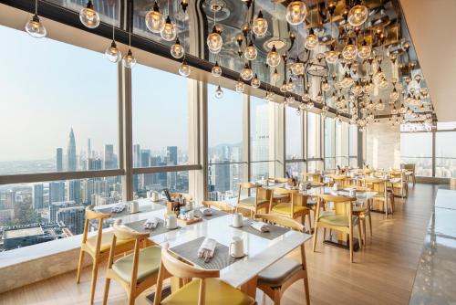 深圳深圳湾万丽酒店的餐厅设有桌椅和大窗户。
