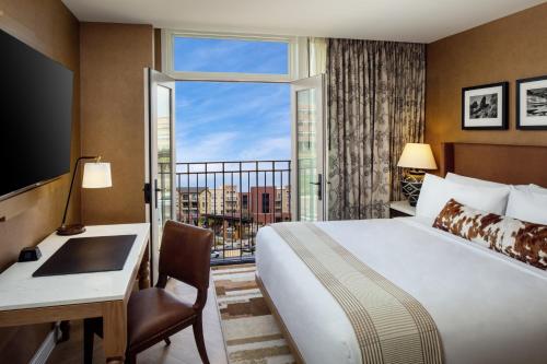奥罗拉The Benson Hotel & Faculty Club的配有一张床、一张书桌和一扇窗户的酒店客房