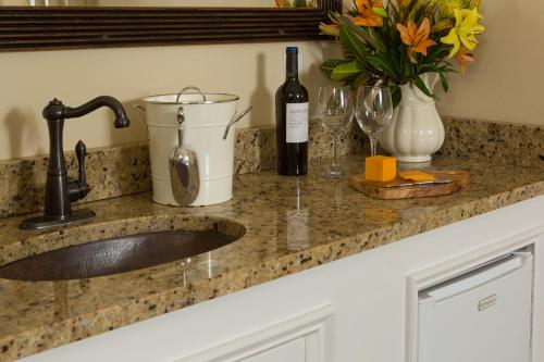 圣奥古斯丁贝拉湾旅馆的带水槽的厨房台面和一瓶葡萄酒