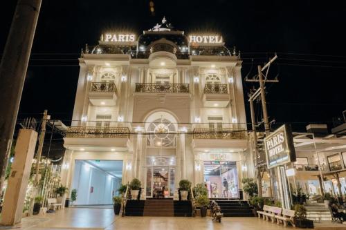 Tuy PhongParis Hotel Bình Thuận的夜间在建筑物前的商店