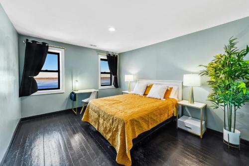 Fox LakeRandolph Hotel的一间卧室配有一张带黄色床罩的床和两个窗户