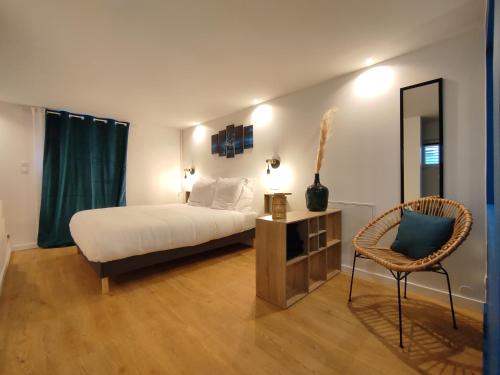 维希Maison de ville, SPA Balnéo, 2 suites parentales的一间卧室配有一张床、一把椅子和镜子