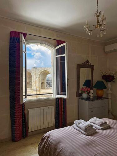 阿尔勒Appartement aux Arènes的一间卧室设有一张床和一个大窗户