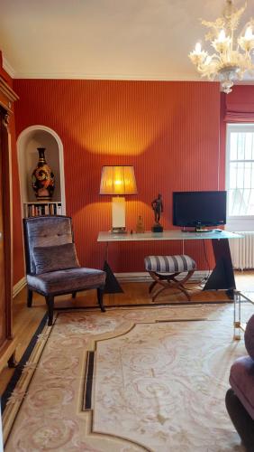 维耶尔宗SUPREMATISME Appartement de Prestige的客厅设有红色的墙壁和椅子