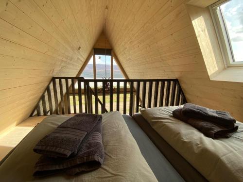 埃基斯蒂尔Hengifosslodge Tiny Houses的房间里的一张床位,上面有两条毛巾