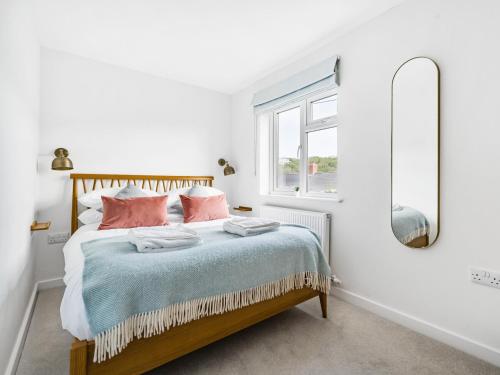 波特里斯Fairwinds的一间卧室配有一张带粉红色枕头和镜子的床