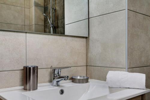 圣勒Leu Burgot 1, Appartement 13的浴室水槽配有镜子和毛巾