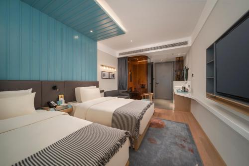 广州CityNote希诺酒店广州北京路纪念堂地铁站店的酒店客房设有两张床和一台平面电视。