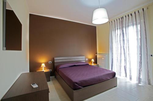 巴里La Dimora Accommodation的一间卧室设有紫色的床和窗户