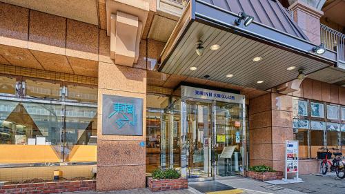 大阪Toyoko Inn Osaka Namba Nishi的建筑物前面的商店,上面有标志