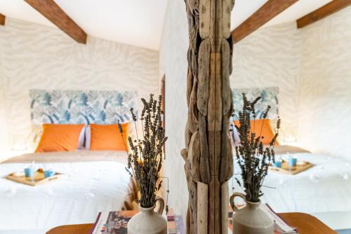 贝端Au petit bonheur的一间卧室配有带橙色枕头的床和两张桌子