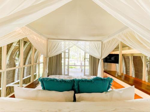 吉利特拉旺安Hotel Lumi Gili Trawangan的一间卧室配有一张带蓝色枕头的天蓬床