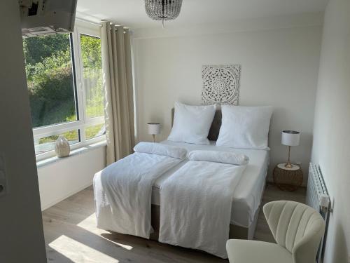 科赫姆Gästehaus Paulina的白色的卧室设有白色的床和窗户。
