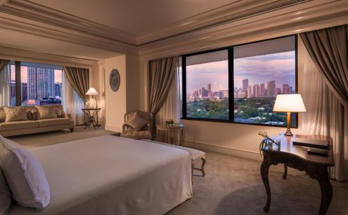 马尼拉The Peninsula Manila的酒店客房设有一张床和一个大窗户