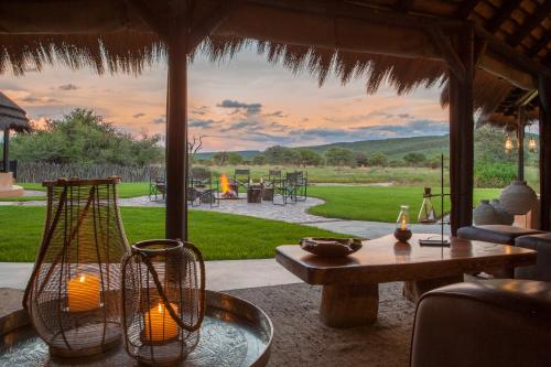 奥奇瓦龙戈Okonjima Luxury Bush Camp的客厅配有桌子和雨伞