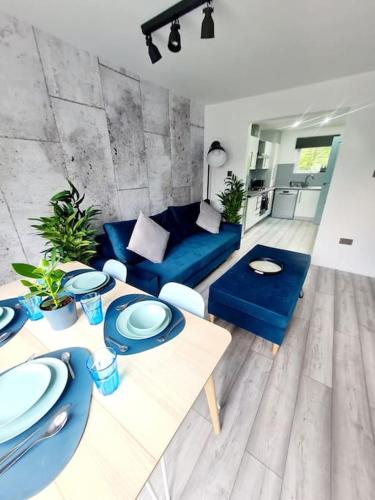 格拉斯哥Spacious 5bed house, FREE parking, NO PARTY !的客厅配有蓝色的沙发和桌子