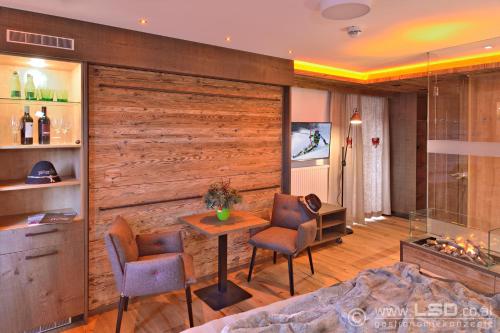 蒂罗尔州圣约翰旁腾豪夫博尔酒店的客厅设有木墙和桌椅