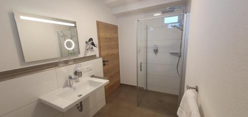 NeuhofLandhotel Imhof的浴室配有盥洗盆和带镜子的淋浴