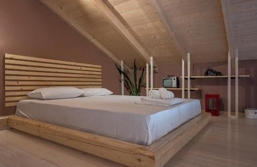普雷韦扎Villa Manolia的卧室配有一张白色大床和木制床头板
