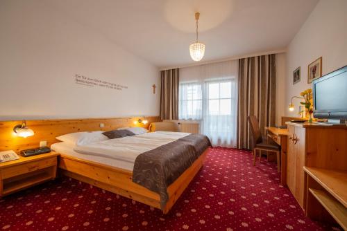 Sankt Oswald古拉克斯兰德费舍尔酒店的配有一张床和一台平面电视的酒店客房