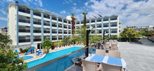 锡德Gazipasa Star Otel的一座带椅子的游泳池和一座建筑的酒店