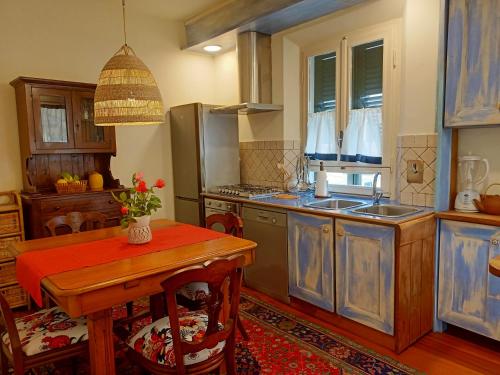马西亚娜马里纳Appartamento Teresina的厨房配有蓝色橱柜和木桌