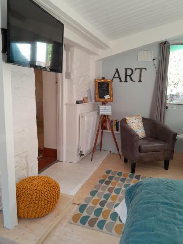 CalstockThe Artist's Retreat的客厅配有平面电视和椅子。