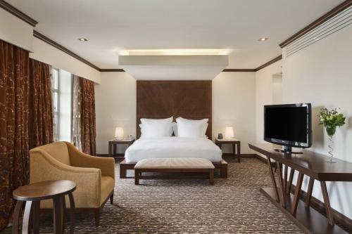 丘达德马拉波Bisila Palace的配有一张床和一台平面电视的酒店客房