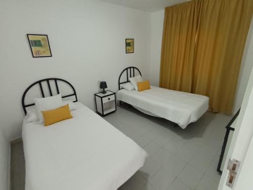 科斯塔特吉塞莫林诺德瓜提萨酒店的一间设有两张床的房间和一个配有两个设施的床头柜