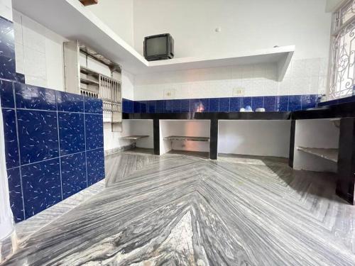马尔冈Entire 2 BHK spacious Apartment on first floor - Sai Homestay的客房铺有蓝色和白色的瓷砖,配有电视。