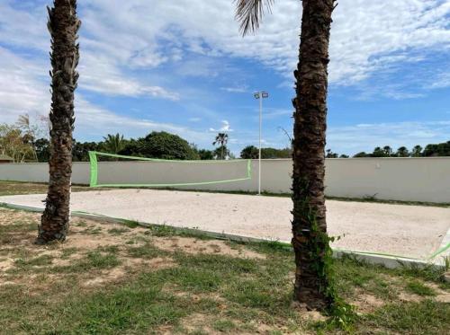 巴雷里尼亚斯Ap Remanso的一座拥有两棵棕榈树的网球场和排球场