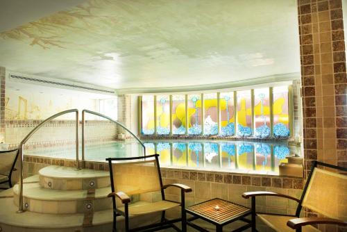 格拉纳达洛杉矶水疗酒店的客房设有带椅子的游泳池和浴缸